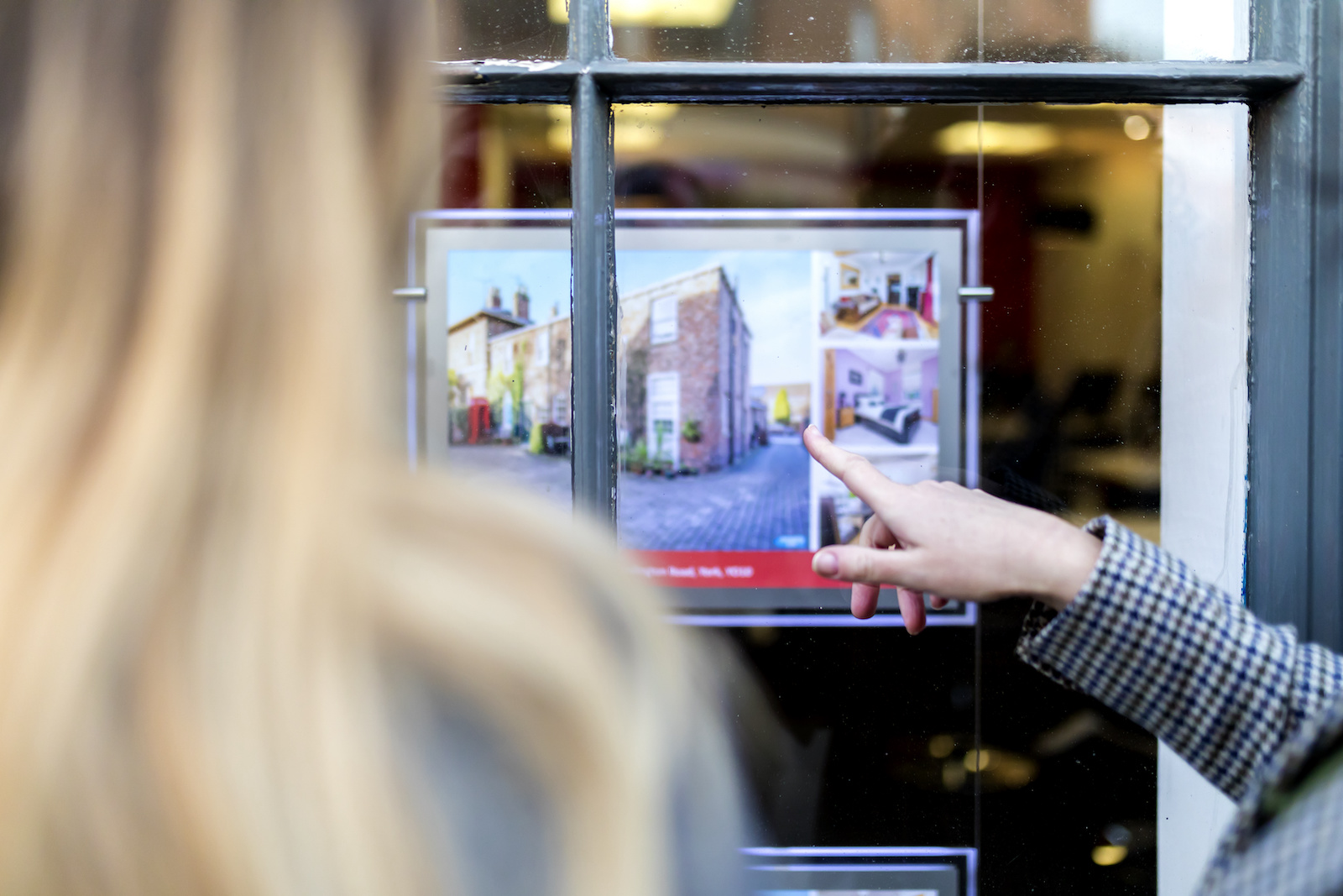couple looking at property value in estate agent window