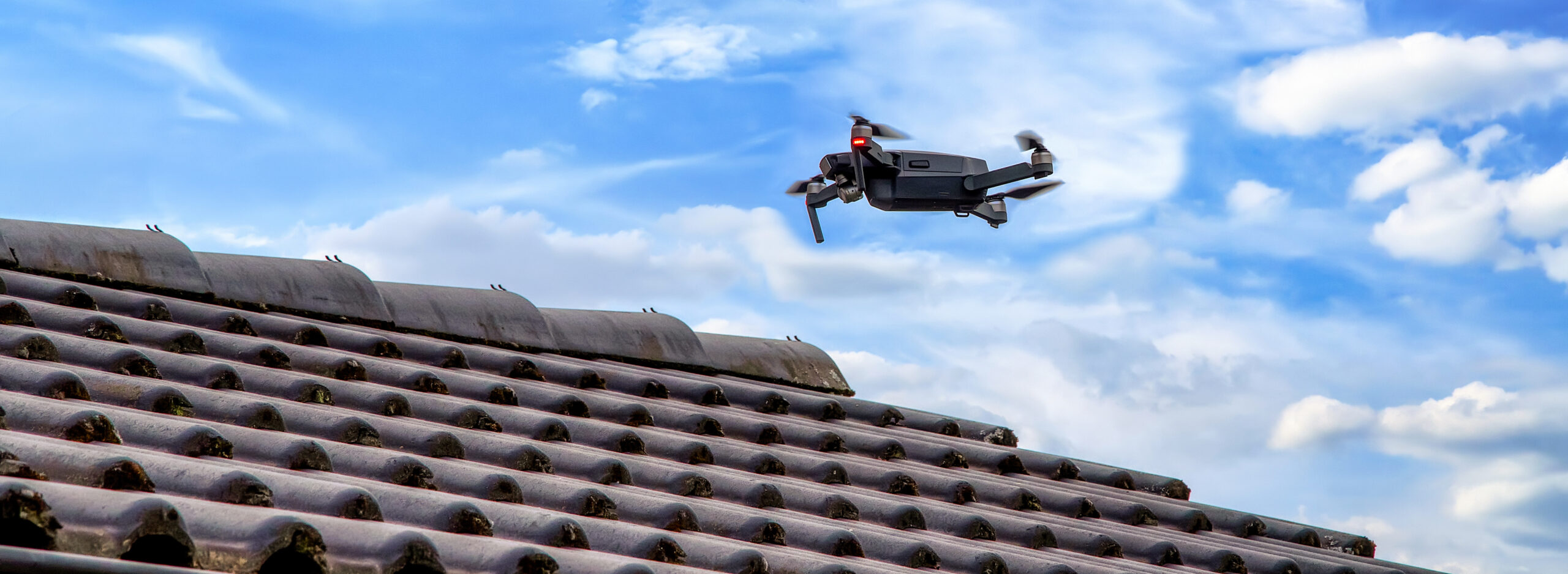 Drone in the air inspecting the roof over the house. Close-up of